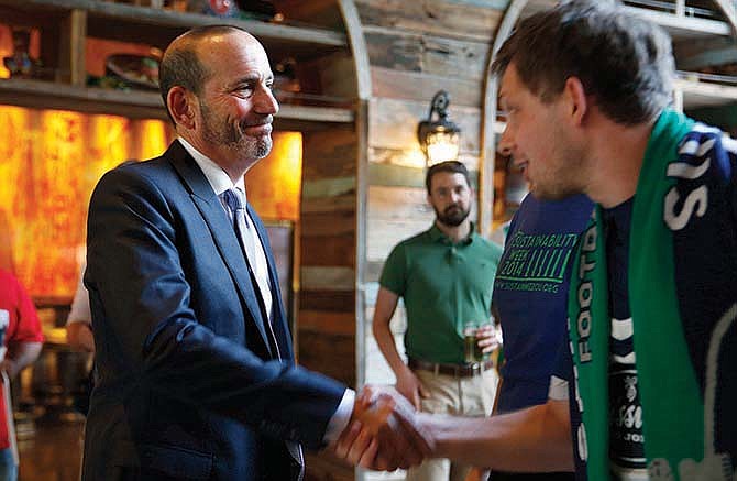 Major League Soccer commissioner Don Garber (left) shakes hands with a fans after
speaking Tuesday in St. Louis about the possible MLS expansion hopes of the city.