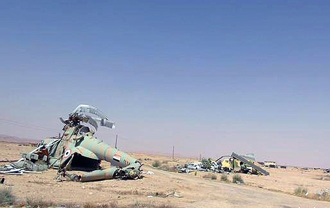 Damaged Syrian military helicopters are shown Thursday at Palmyra air base, which was captured by the Islamic State militants after a battle with the Syrian government forces in Palmyra, Syria.