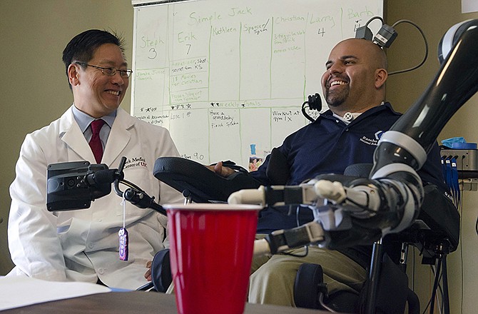 Dr. Charles Y. Liu, left, a neurosurgeon at the University of Southern California, laughs in April with patient Erik Sorto in Pasadena, California. Liu led a team of doctors that implanted tiny chips into Sorto's brain in 2013 to allow him to control a robotic arm using his thoughts. 