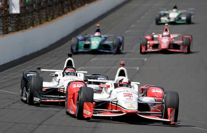 Juan Pablo Montoya, of Colombia, leads Will Power, of Australia, into the first turn on the 198th laps on his way to winning the 99th running of the Indianapolis 500 auto race at Indianapolis Motor Speedway in Indianapolis, Sunday, May 24, 2015.