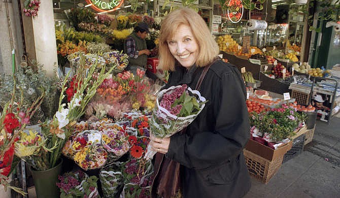  In this April 1, 1995, file photo, actress and comedian Anne Meara picks up a bouquet at a sidewalk market in New York City. Meara, whose comic work with husband Jerry Stiller helped launch a 60-year career in film and TV, has died. She was 85. Jerry Stiller and his son Ben Stiller say Meara died Saturday, May 23, 2015.