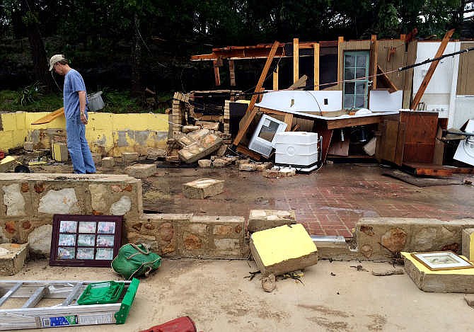 Gordon Welch surveys damage to the house his family has owned since 1964 along River Road next to the Blanco River in Wimberley, Texas, Sunday, May 24, 2015. Welch said that he and his wife watched the house get swept away by flood water. (Kelly West/Austin American-Statesman, statesman.com, via AP)