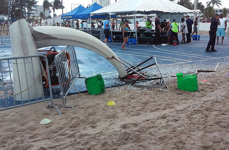 In this photo provided by Burt Osteen, glass is scattered around a toppled basketball hoop after a waterspout made landfall at Fort Lauderdale Beach, Fla. on Monday. Authorities say three children were injured when the waterspout uprooted a bounce house and sent it across a parking lot into the road. 
