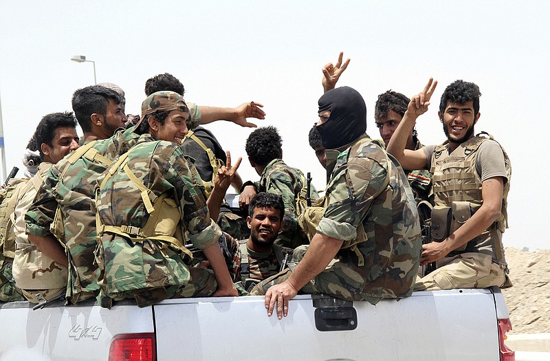 Shiite militiamen arrive to Khalidiya to support Sunni tribal fighters and local policemen as they defend their city against Islamic State group militants, 60 miles west of Baghdad, Iraq. 