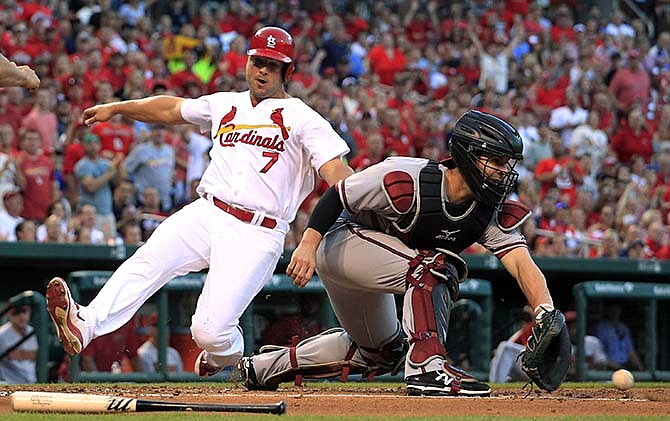 St. Louis Cardinals' Matt Holliday, left, scores as Arizona Diamondbacks catcher Tuffy Gosewisch handles the throw during the first inning of a baseball game Tuesday, May 26, 2015, in St. Louis.