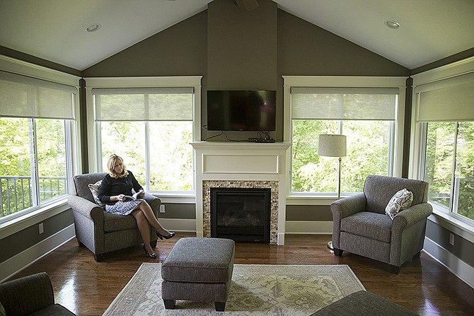 Lisa Kremer reads in her new sunroom, built by Markway Construction and Tina Davis of Designs by Tina. Sunrooms can add extra living space while providing the outdoor feel 365 days a year. 