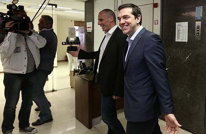 Greece's Prime Minister Alexis Tsipras, right, is welcomed by Finance Minister, Yanis Varoufakis, during his visit at the Finance Ministry in Athens Wednesday, May 27, 2015. Greece is out of cash to repay debts due as soon as next week. The country and its creditors - other eurozone countries and the International Monetary Fund - have been locked in negotiations for months on what reforms the southern European country needs to take to get the final batch of loans from its international bailout. 