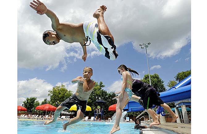 In this July 2, 2014 News Tribune file photo, Bryce Riegel, top, gets some serious hang time as he and a group of friends including, from left, Owen Reider, Lottie Cole and Tyler Surface plunge into the deep end during a cool and breezy day of swimming at the Memorial Park Aquatic Center.