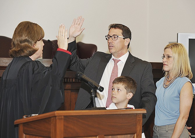 Michael Barrett repeats the oath of office as performed by Judge Mary Russell during his swearing-in Thursday, May 28, 2015, as the state public defender. Barrett was sworn in during a brief ceremony in the Supreme Court District II Hearing Room. He was accompanied by his wife, Sebrina, and eight-year-old son, Mason.