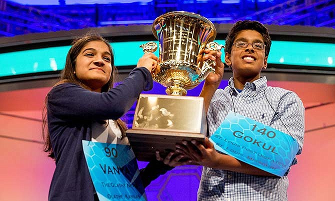 Vanya Shivashankar, left, 13, of Olathe, Kan., and Gokul Venkatachalam, 14, of St. Louis, hold up the championship trophy as co-champions after winning the finals of the Scripps National Spelling Bee, Thursday, May 28, 2015, in Oxon Hill, Md.