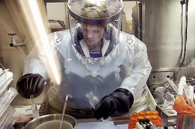 In this May 11, 2003, file photo, Microbiologist Ruth Bryan works with BG nerve agent simulant in Class III Glove Box in the Life Sciences Test Facility at Dugway Proving Ground, Utah. The specialized airtight enclosure is also used for hands-on work with anthrax and other deadly agents. The Centers for Disease Control and Prevention said it is investigating what the Pentagon called an inadvertent shipment of live anthrax spores to government and commercial laboratories in several states and overseas, which expected to receive dead spores. 