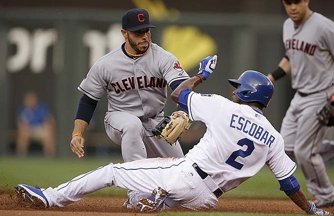 Kansas City Royals' Alcides Escobar beats the tag by Cleveland Indians shortstop Mike Aviles, back, during the first inning of a baseball game at Kauffman Stadium in Kansas City, Mo., Thursday, June 4, 2015. Escobar stole second base on the play.