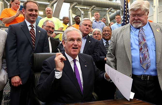 Missouri Gov. Jay Nixon signs a ceremonial veto of the controversial "right-to-work" legislation on Thursday, June 4, 2015, at the Sheet Metal Workers Local 36 training facility in St. Louis. The actual veto was signed earlier in the day in Jefferson City. (Laurie Skrivan/St. Louis Post-Dispatch via AP)