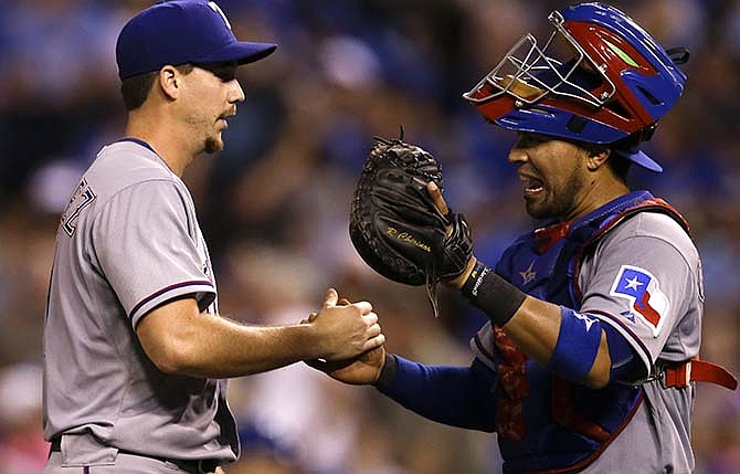 Texas Rangers starting pitcher Chi Chi Gonzalez, left, is congratulated by catcher Robinson Chirinos, right, following a baseball game against the Kansas City Royals at Kauffman Stadium in Kansas City, Mo., Friday, June 5, 2015. Gonzalez pitched a complete-game shutout of the Royals. The Rangers defeated the Royals 4-0.
