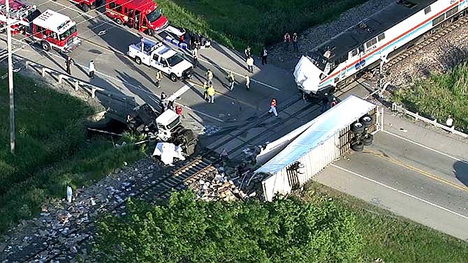 In this frame made from video, personnel work at the scene of an Amtrak train that slammed into a semitrailer Friday, June 5, 2015, at a crossing near Wilmington, Ill. The train, the Texas Eagle, which left San Antonio on Thursday for Chicago, hit the trailer of the truck that was obstructing the tracks. 