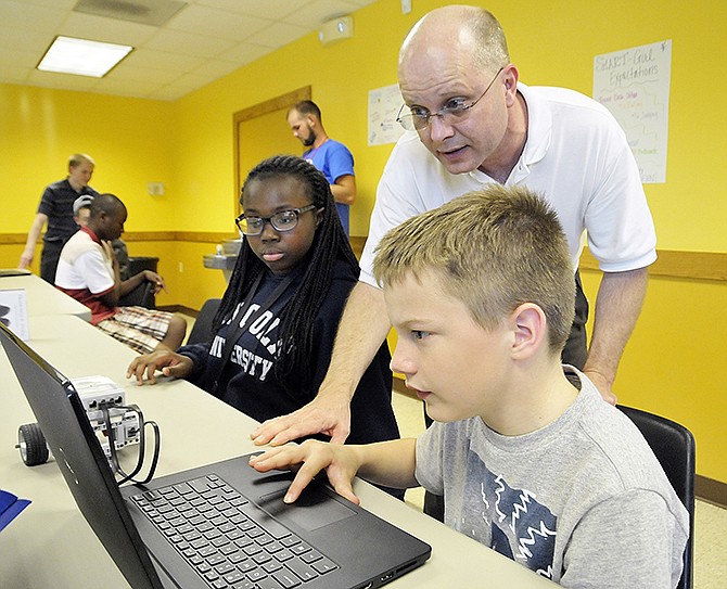 John Smallwood of STI Technology Solutions works with Hunter Walling, 12, and Jerica Austin, 11, to program their robot during Monday's class at the Dorothy Pack Community Center on Edmonds Street. The Boys and Girls Club of the Capital City was awarded a $1.8 million grant to expose middle school children to science, technology, engineering, art and math.