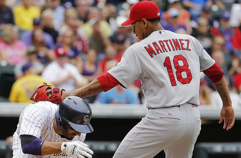 Cardinals starting pitcher Carlos Martinez tags out Daniel Descalso of the Rockies during the fourth inning of Wednesday afternoon's game in Denver.