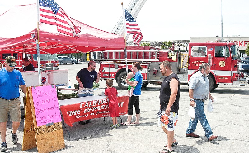 Customers order and volunteer firefighters of the California Fire Department prepare and sell the barbecued ribs, sandwiches and chicken at the annual fundraiser at Village Green Shopping Center.