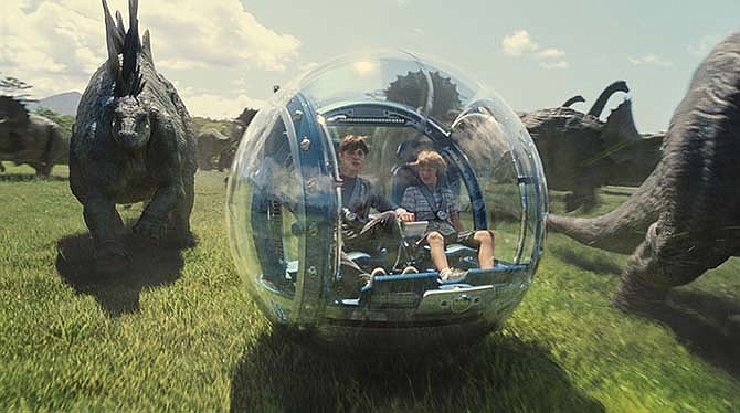 This photo provided by Universal Pictures shows, Nick Robinson, left, as Zach, and Ty Simpkins as Gray, in a scene from the film, "Jurassic World," directed by Colin Trevorrow, in the next installment of Steven Spielberg's groundbreaking "Jurassic Park" series.