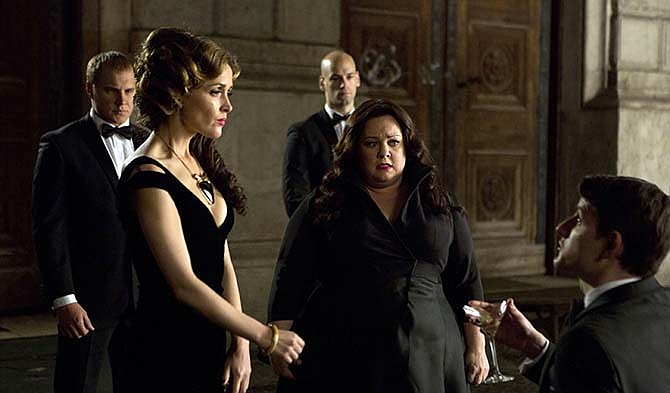 This photo provided by Twentieth Century Fox shows, Melissa McCarthy, second right, infiltrating an arms dealing ring led by Rose Byrne, left, in a scene from the film, "Spy."