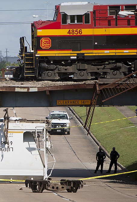 Authorities investigate the scene of a train accident along Old Katy Road, Thursday in Houston. Authorities say a freight train derailed on a bridge over the Houston highway and at least one car fell onto the road below. 