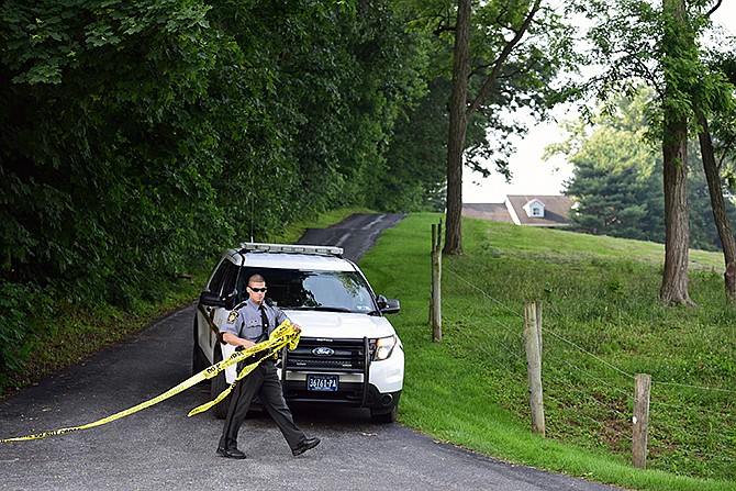 A Pennsylvania state trooper tapes off a driveway Thursday at a residence on Spring Valley Road in Quarryville, Pennsylvania. A man facing trial on child sexual assault charges fatally stabbed a woman and her 16-year-old daughter at the residence "to silence them" because they were set to testify against him, a prosecutor said Friday, calling it an "absolute attack on the system."