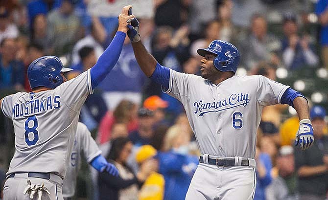 Kansas City Royals' Mike Moustakas, left, greats Lorenzo Cain at home after Cain hit a two-run home run off of Milwaukee Brewers' Matt Garza during the first inning of a baseball game Tuesday, June 16, 2015, in Milwaukee. 