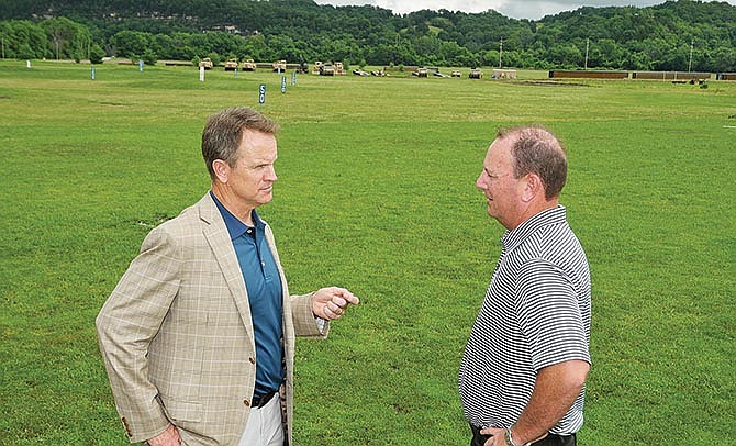 Jon Sunvold (left) and Scott Hovis discuss plans for the new undertaking at Turkey Creek
Golf Center in north Jefferson City. In the background is some of the large equipment that
will be used to move dirt to make the nine-hole course.