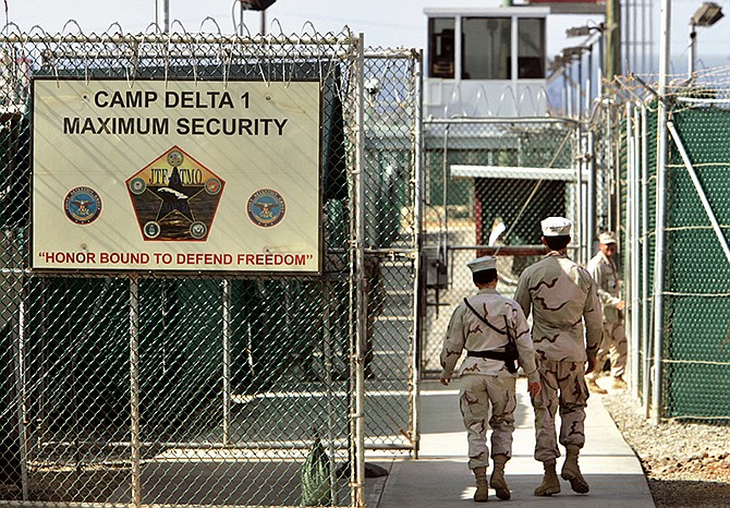 U.S. military guards walk within Camp Delta military-run prison in 2006 at the Guantanamo Bay U.S. Naval Base, Cuba. President Barack Obama's declaration that the U.S. is no longer at war in Afghanistan has given rise to new legal challenges from Guantanamo Bay detainees who were captured in that country, but say there's no longer any legal basis to hold them.