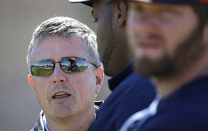In this Feb. 18, 2013, file photo, Houston Astros general manager Jeff Luhnow, left, talks with players during a spring training baseball workout in Kissimmee, Fla. 