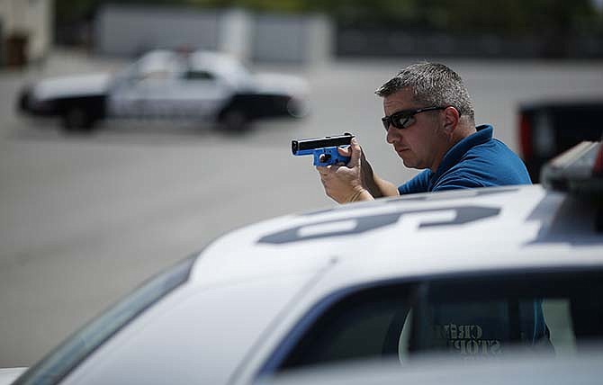 In this May 12, 2015 photo, a Las Vegas police officer takes part in a training exercise in Las Vegas. The city has tested many changes as the first police department in the country to complete a "collaborative" Justice Department review. Some critics said it did not go far enough. But shootings by officers, which peaked at 25 in 2010, declined to 13 in 2013 and 16 in 2014. In 2015, through mid-June, Metro officers shot three people, killing one. 