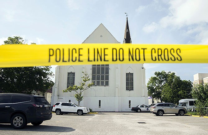 Police tape surrounds the parking lot behind the AME Emanuel Church as FBI forensic experts work the crime scene Friday in Charleston, South Carolina. Dylann Storm Roof, 21, is accused of killing nine people during a Wednesday night Bible study at the church.