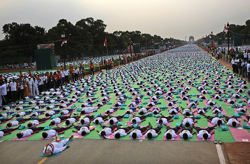 Indian Prime Minister Narednra Modi, left front, lies down on a mat as he performs yoga along with thousands of Indians on Rajpath, in New Delhi, India, Sunday. Millions of yoga enthusiasts are bending their bodies in complex postures across India as they take part in a mass yoga program to mark the first International Yoga Day