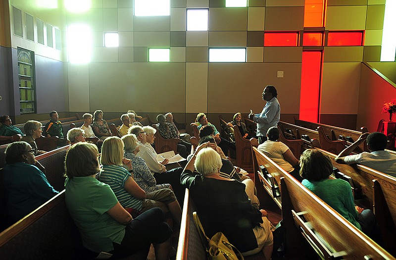 Dr. Carl Kenney, II, co-pastor of Bethel Baptist Church in Columbia and a professor of journalism at the University of Missouri, addresses a gathered crowd of approximately two dozen people while speaking at Quinn Chapel AME Church on Monday evening. 