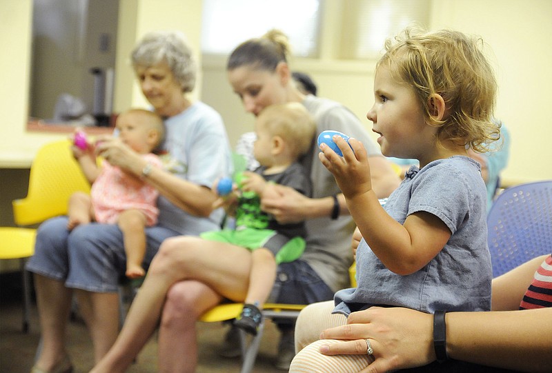 Children shake plastic eggs on Monday at the Callaway County Library during "The Beginning Years" event.