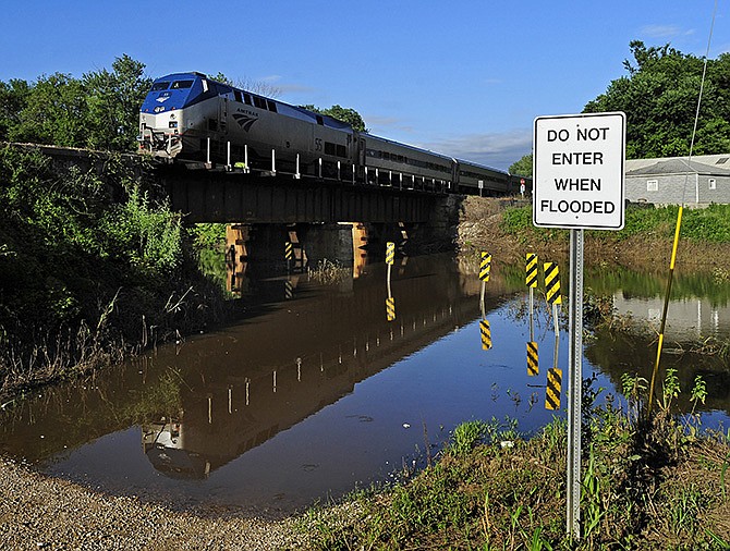The Amtrak Missouri River Runner makes its way west toward Kansas City Friday as it crosses over the flooded Grays Creek at Cole Junction Road after departing from the Jefferson City depot.
