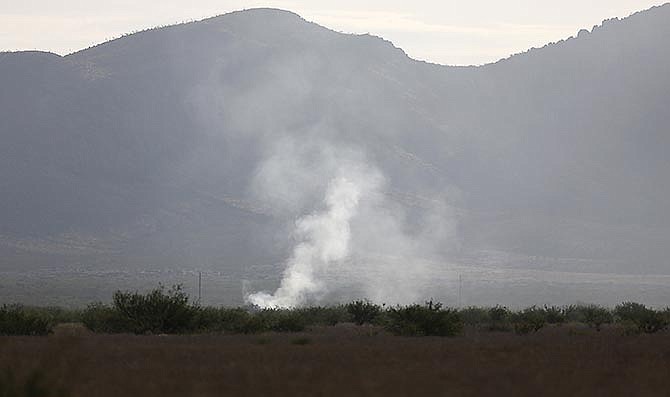 Smoke rises Thursday, June 25, 2015, from the site where an F-16 Fighting Falcon crashed Wednesday evening near Douglas, Ariz. The pilot's identity and condition is unknown at this time. (Mamta Popat/Arizona Daily Star via AP)