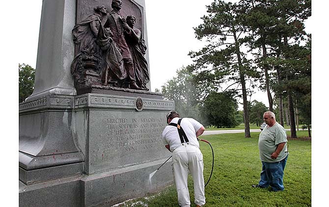 In this June 24, 2015, file photo, St. Louis Parks workers clean a Confederate memorial in St. Louis after it was spray painted with the words, "Black lives matter." Confederate monuments in a half-dozen places this week have been defaced _ a telling sign of the racial tension that permeates post-Ferguson America. (David Carson/St. Louis Post-Dispatch via AP, File)