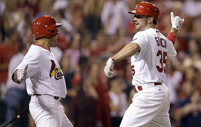 St. Louis Cardinals' Greg Garcia, right, is congratulated by teammate Kolten Wong after hitting a solo home run during the eighth inning of a baseball game against the Chicago Cubs on Friday, June 26, 2015, in St. Louis. 