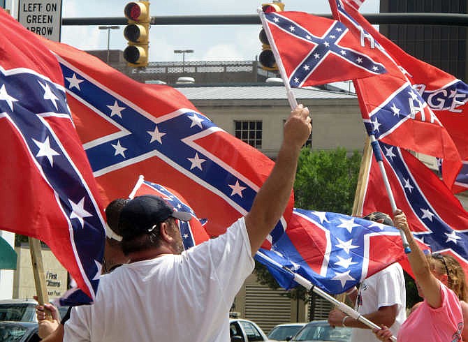 Supporters of keeping the Confederate battle flag flying at a Confederate monument at the South Carolina Statehouse wave flags during a rally in front of the statehouse in Columbia, S.C., on Saturday, June 27, 2015. Gov. Nikki Haley and a number of other state leaders have called for the removal of the flag following the shooting deaths of nine black parishioners in a church in Charleston last week. 