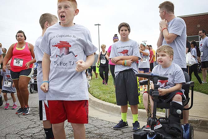 TJ Clime, right, watches runners leave the
starting line Saturday as his best friend
Jamisen Schwarzer cheers on participants
during the Run Cupcake Run 5K at Thomas
Jefferson Middle School in Jefferson City.