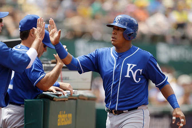 Kansas City Royals' Salvador Perez, right, celebrates after scoring against the Oakland Athletics in the sixth inning of a baseball game Sunday, June 28, 2015, in Oakland, Calif. Perez scored on a single by teammate Omar Infante. 
