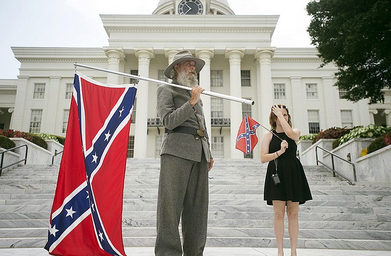 Dan Williams, 65, of Ashville, Ala., holds a Confederate flag while standing with his daughter Bonnie-Blue Williams, 15, in front of the Alabama State Capitol building during a Confederate flag rally in Montgomery, Ala.