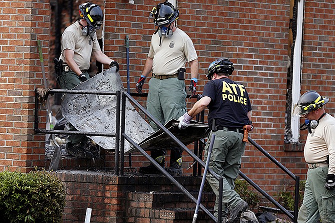 Investigators from the Bureau of Alcohol, Tobacco, Firearms and Explosives and the South Carolina Law Enforcement Division remove the remains of a door from the Mount Zion African Methodist Episcopal Church, Wednesday in Greeleyville, South Carolina. The African-American church, which was burned down by the Ku Klux Klan in 1995, caught fire Tuesday night, but authorities said arson is not the cause. 