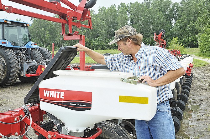 Jay Fischer's farm tractor and planter currently sit in a muddy field waiting for it to dry out enough to be able 