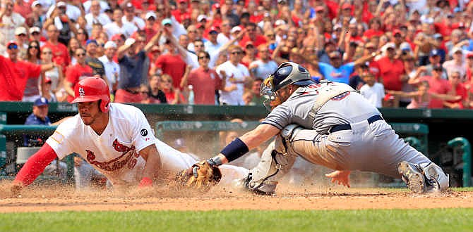 St. Louis Cardinals' Tommy Pham, left, scores past San Diego Padres catcher Derek Norris during the eighth inning of a baseball game Saturday, July 4, 2015, in St. Louis. The Cardinals won 2-1.