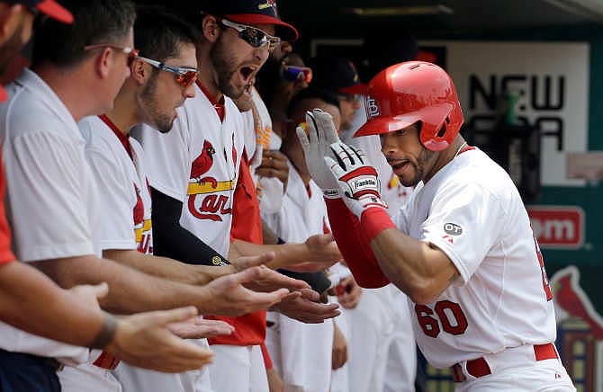 St. Louis Cardinals' Tommy Pham (60) is congratulated by teammates in the dugout after hitting a two-run home run during the third inning of a baseball game against the San Diego Padres, Sunday, July 5, 2015, in St. Louis. (