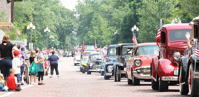 Attendants of the Independence Day parade watch as a series of vintage cars drive past Saturday. It is Fulton's fourth year hosting the parade which was in honor of the Callaway Vietnam Veterans.