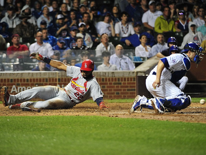 Jason Heyward of the Cardinals slides safely into home for a run as Cubs catcher Miguel Montero takes the throw during the seventh inning of a Monday night's game in Chicago.