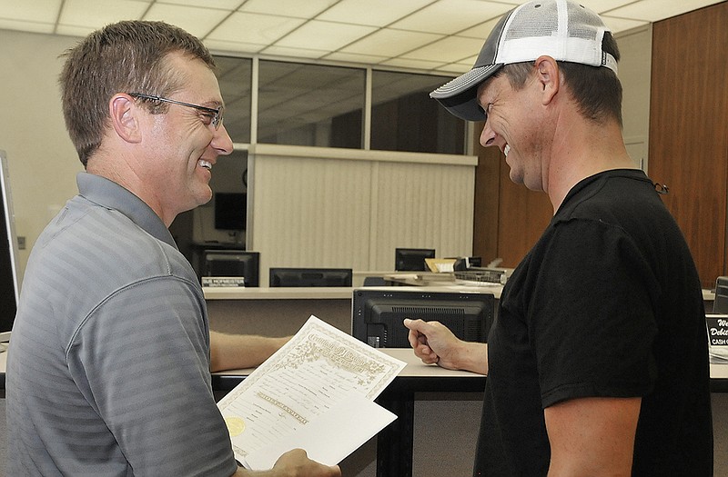 Ted Henke, left, and Steve Barnes are all smiles as they receive their marriage license, the first same-sex license issued in Cole County since the Supreme Court ruled that same-sex marriage was legal in all states. 